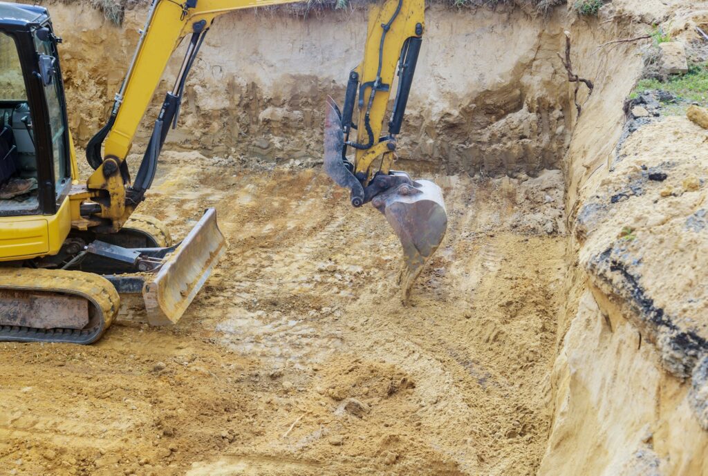 Excavator during earthworks backhoe on work digs ground during earthworks for the foundation
